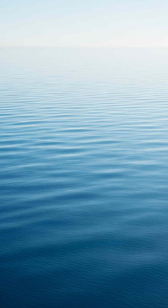 A serene ocean landscape with calm water and a clear blue sky