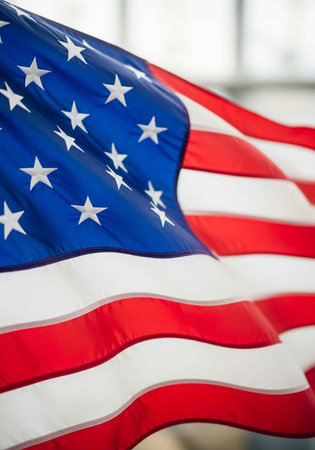 The American flag waving proudly in a bright and airy indoor setting with a blurred background.