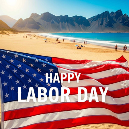 A large American flag waving on a beach with mountains in the background on Labor Day
