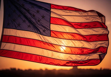 The American flag waving in the wind during a beautiful sunset with vibrant colors in the sky