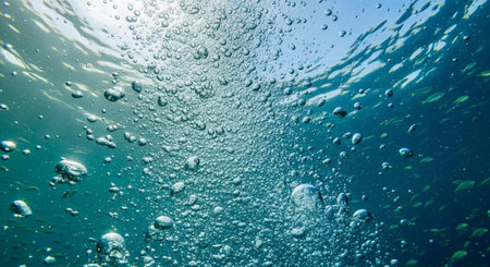 An underwater scene with bubbles rising to the surface of the ocean with small fish swimming