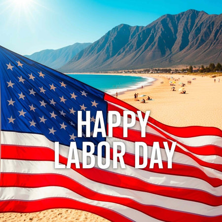 A large American flag waving on a beach with people and mountains in the background on Labor Day