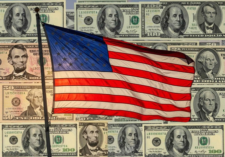 The American flag waving proudly in front of a background of US dollar bills and hundred dollar bills.の写真素材