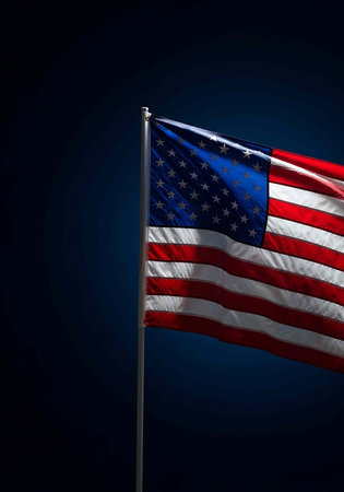 USA flag with red, white, and blue colors flying on a silver pole at night