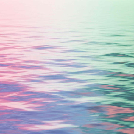 Calm ocean surface with pastel pink, blue, and green hues and gentle waves