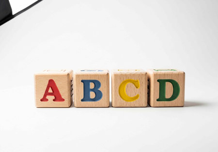 A close-up photo of wooden alphabet blocks arranged in a row on a white background
