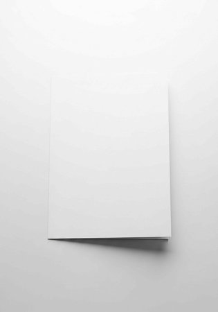 A single sheet of white paper with a slight shadow on a light gray surfaceの写真素材