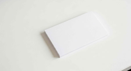 Single white business card with smooth surface and slight shadow on plain white surfaceの写真素材