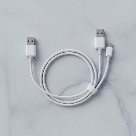 Coiled white USB cable with two connectors on a marble background