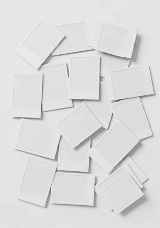 A collection of blank white Polaroid photos scattered on a plain surface