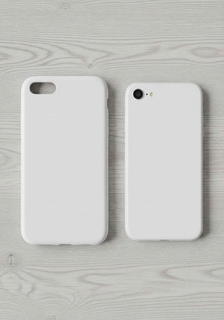Two white phone cases on a light gray wooden surface, one with a cutout for the camera lens