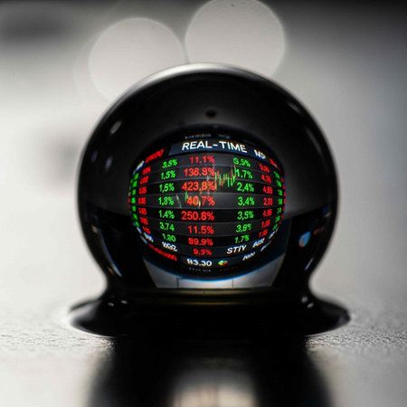 A sleek black device shows stock market data in red, green, and white on a gray background.