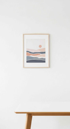 A framed abstract landscape artwork hangs on a white wall above a wooden table