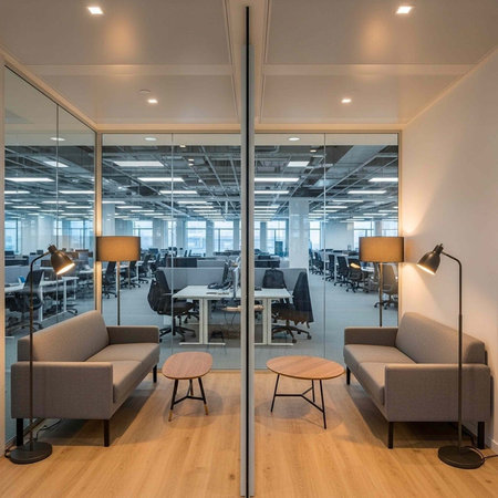 A modern office space with a comfortable seating area and a large open workspace in the background