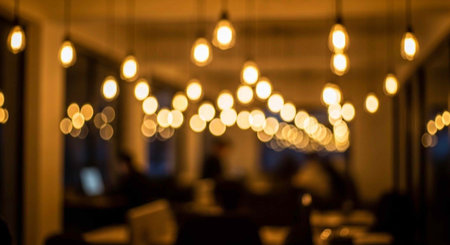 A dimly lit restaurant interior with warm glowing light bulbs hanging from the ceiling