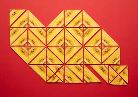 A creative mosaic artwork made of yellow and red triangular tiles on a red backgroundの写真素材