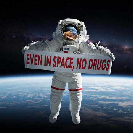 An astronaut in a white spacesuit holds a sign that reads 'EVEN IN SPACE, NO DRUGS' while floating...