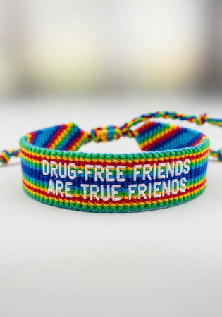 A colorful woven bracelet with a message about true friendship on a white backgroundの写真素材