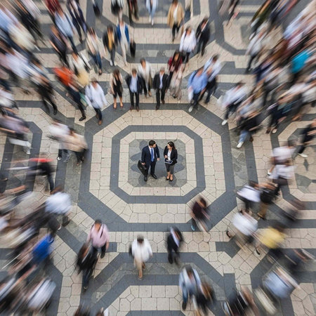 A busy office building lobby with people walking in every direction around a central meeting point