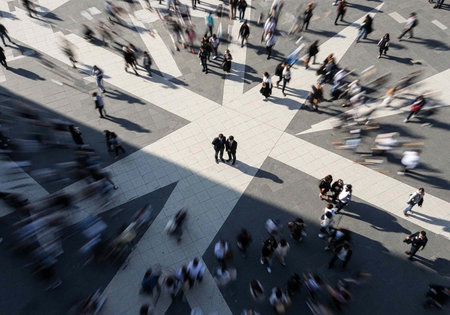 A bustling city street with people walking in all directions on a busy urban crosswalk