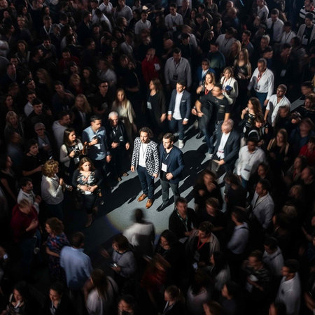 A large crowd of people gathered in a dark room with a spotlight shining down on a few individualsの写真素材