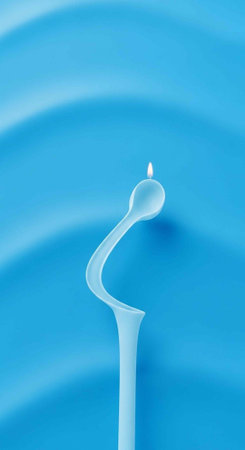 A unique blue candle with a wavy shape and a small flame burning brightly on top