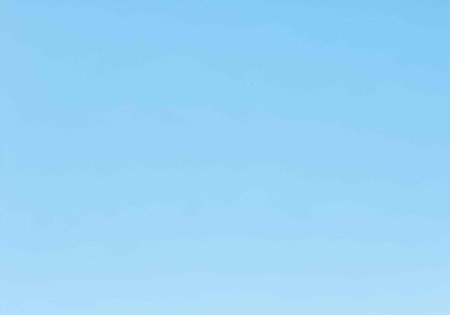 A serene blue sky with a gradient of light and vibrant colors in a peaceful natural landscape