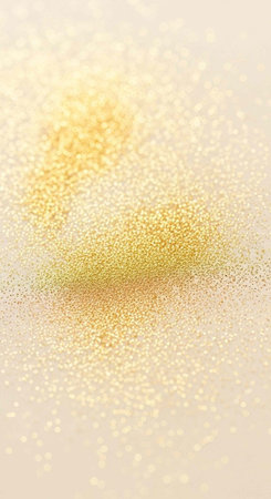 A close-up view of sparkling golden particles on a beige background with a soft focus effect
