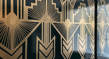 A close-up view of an art deco design with gold and black geometric patterns