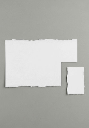 A torn white paper note on a gray background with a smaller note