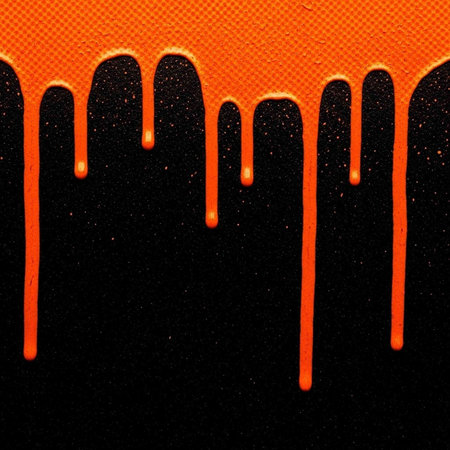 An abstract image of orange liquid dripping down a black background with a textured surface