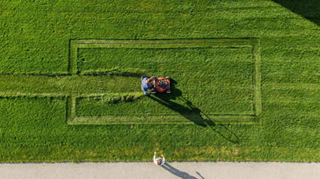 Aerial view of a couple driving a lawn mower in a park