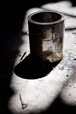Still life shot of a rusty old paint bucket under dramatic lighting.