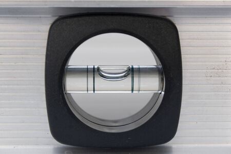 A closeup of a carpenters bubble level with a brushed aluminum finish.