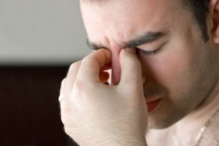A young man that has an intense headache.の写真素材