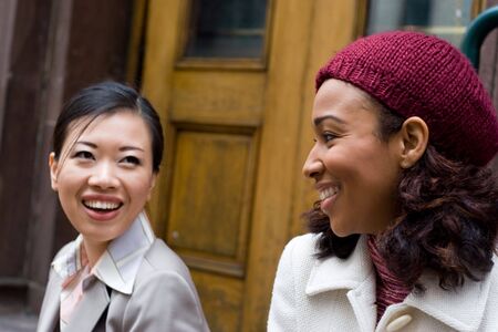 Two business women having a casual meeting or discussion in the city.  Shallow depth of field.の写真素材