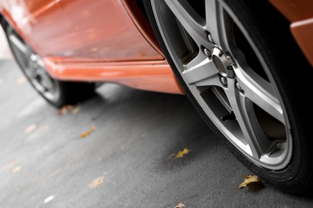 A closeup of the custom rims on a modern sports car with plenty of copyspace.  Shallow depth of...