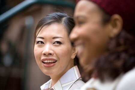Two business women having a casual meeting or discussion in the city. Shallow depth of field.の写真素材