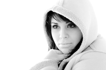A young hispanic woman with a hood on her head in black and white.の写真素材