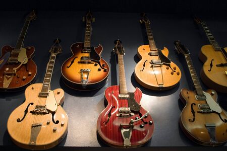 A wall with vintage guitars hanging on display.の写真素材