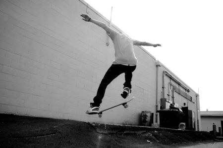 A young skateboarder doing a stunt in an urban area.