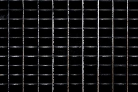 A metal subway grate texture that is worn and weathered.