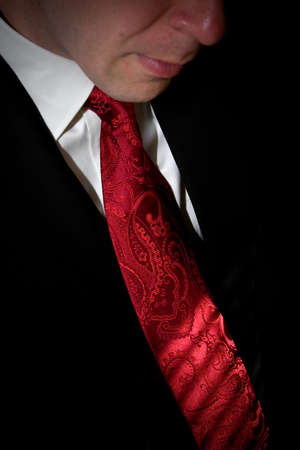 Closeup detail of a groom or business man in a tuxedo with a red tie.の写真素材
