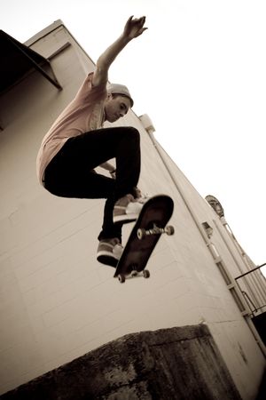 A young skateboarder launches off a concrete loading dock in an urban setting.の写真素材