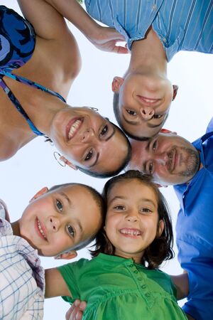 A happy family posing in a group huddle formation.の写真素材