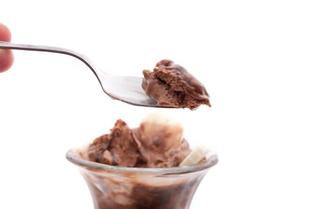 A delicious chocolate ice cream sundae with bananas isolated over a white background. Shallow depth of field.  Sharpest focus on the spoon.の写真素材