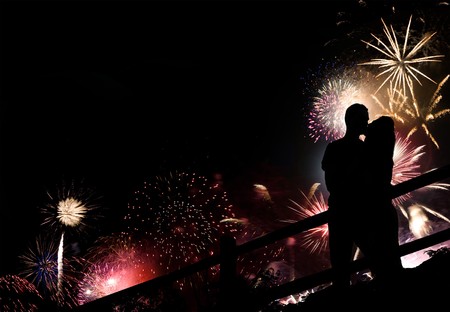 A silhouette of a kissing couple in front of a huge fireworks display.の写真素材