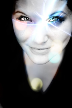 An abstract womans portrait with a glowing lens flare on her face.の写真素材