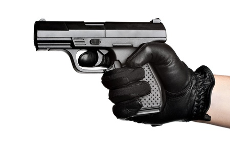 Close up of a persons hand wrapped in a leather glove gripping and aiming a semiautomatic handgun...