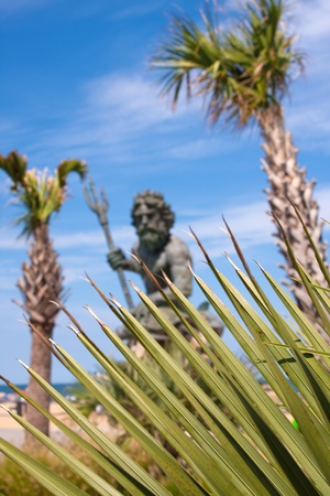 The large public statue of King Neptune in Virginia Beach.  Shallow depth of field with sharp focus on the green tropical foliage.の写真素材